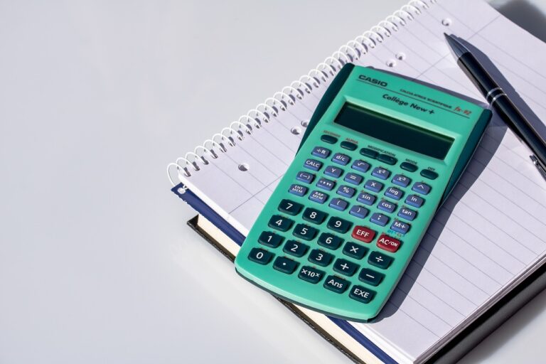 Calculatrice et documents financiers illustrant les erreurs financières courantes et la gestion budgétaire »