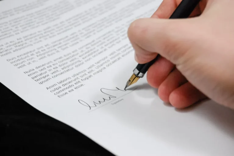 Signature d’un contrat de prêt immobilier avec stylo et documents officiels.