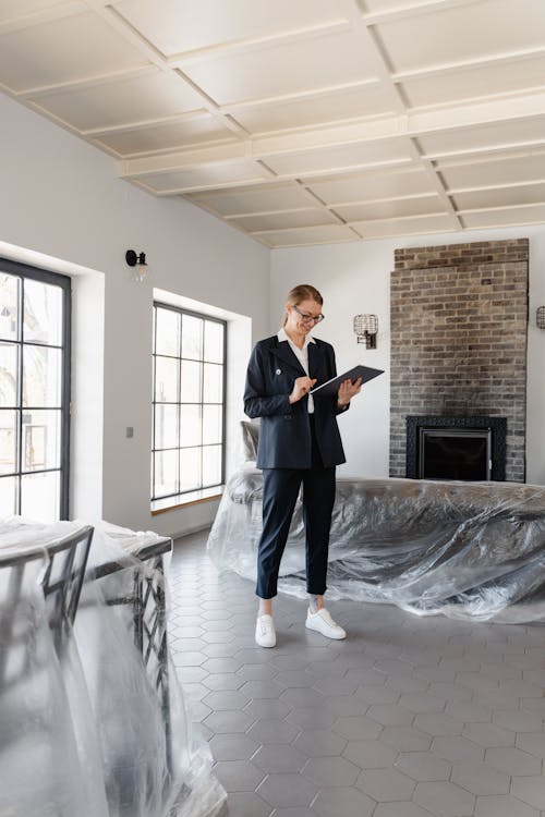 Travaux de rénovation immobilière dans un appartement, avec des ouvriers à l’œuvre, des matériaux de construction et des outils sur place.